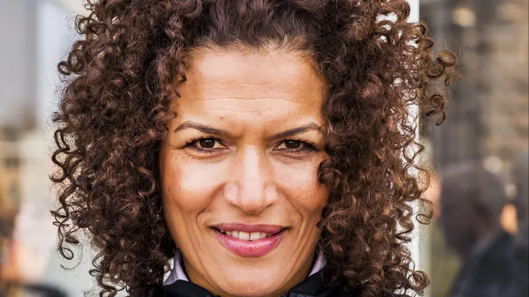 Lachende mevrouw met bruine krullen