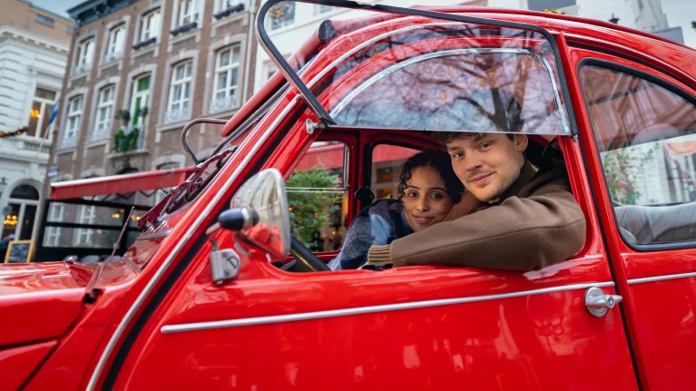 twee mensen in een rode auto
