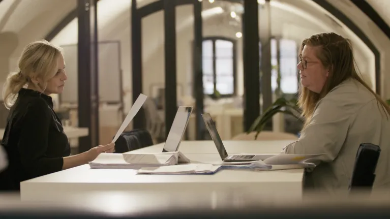 Twee vrouwen aan een tafel met laptops voor zich
