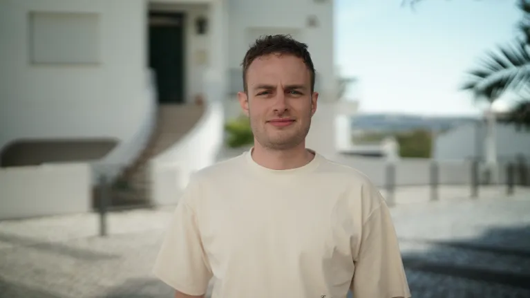 Man voor gebouw met palmbomen