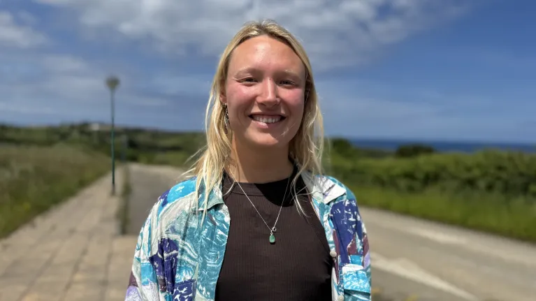 Vrouw in blauw jasje lachend naar camera