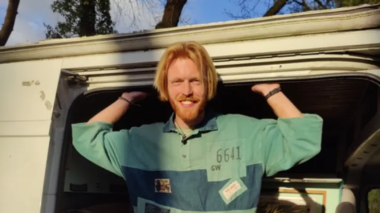 Man staat in de deuropening van een camper 