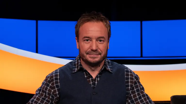 Man met geruite blouse en blauw gilet 