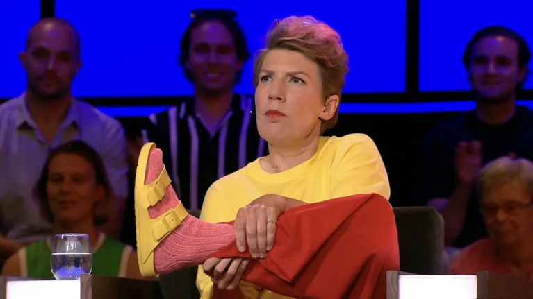 Vrouw houdt haar voet met roze sok omhoog