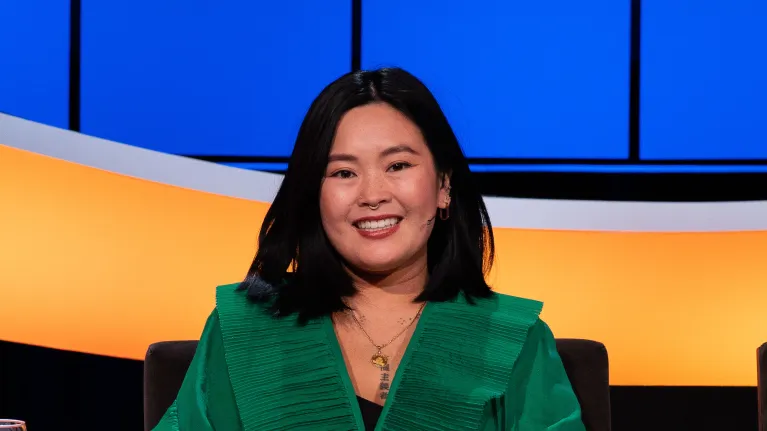 Lachende mevrouw met zwart haar en groene blouse