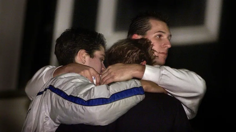 Mensen troosten elkaar bij herdenking