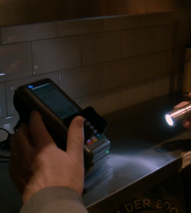 FIOD-medewerker kijkt naar pin-apparaat