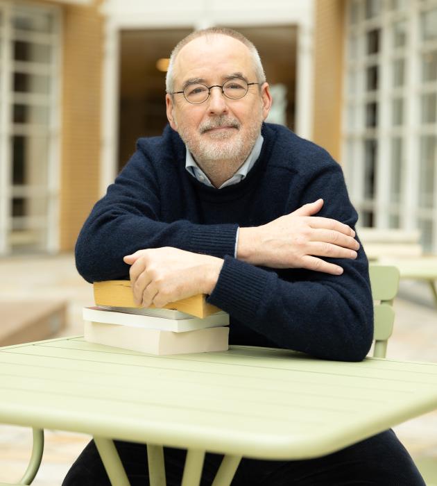 Ronald Giphart aan tafeltje met boeken