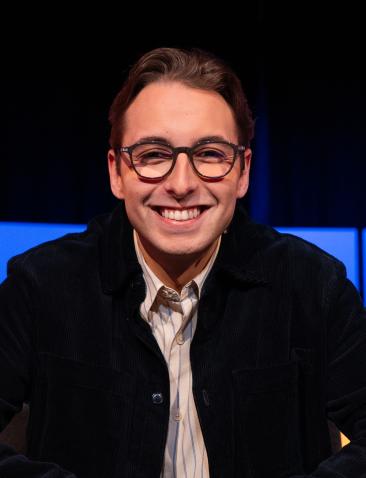 Jongen met bril en zwart vest in de studio