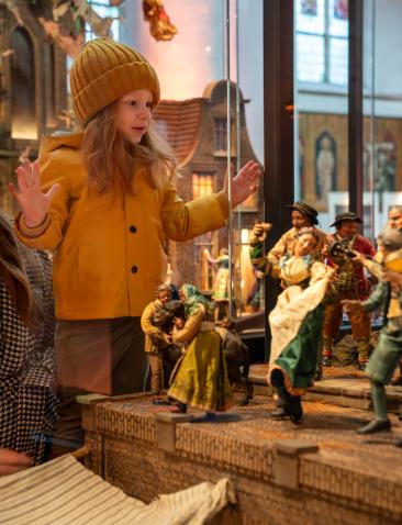 Meisje en vrouw kijken naar kerststal