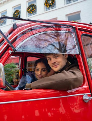 twee mensen in een rode auto