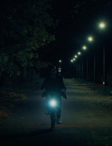 Een man op een fiets in het donker