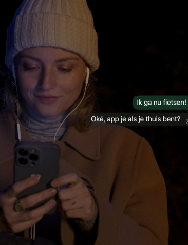 een vrouw met een muts stuurt een bericht op haar telefoon