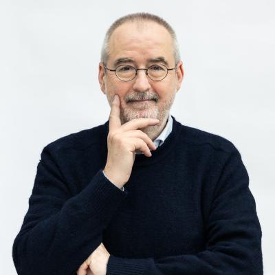 Man in zwarte trui voor witte muur