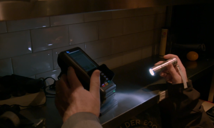 FIOD-medewerker kijkt naar pin-apparaat