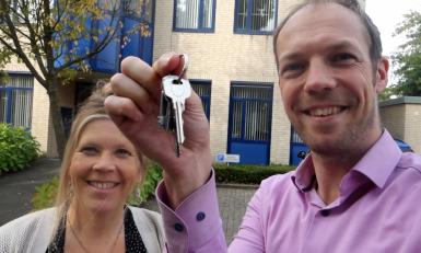 Man en vrouw blij met sleutel omhoog