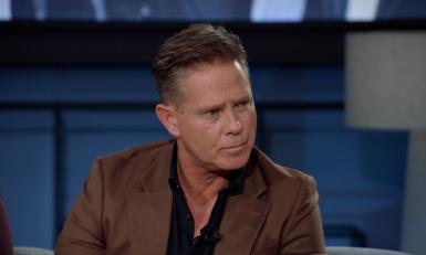 Man in bruin pak in studio kijkend naar rechts