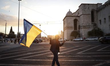 iemand met een wapperende oekraiense vlag met ondergaande zon