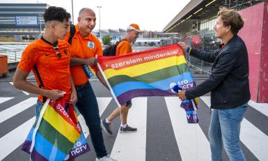 KRO-NCRV presentator Klaas van Kruistem deelt regenboog vlaggen uit