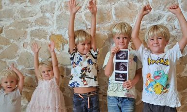 De kinderen van de familie Verleg juichend met een echofoto