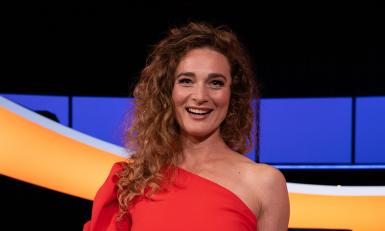 Lachende vrouw in rode jurk met schaal