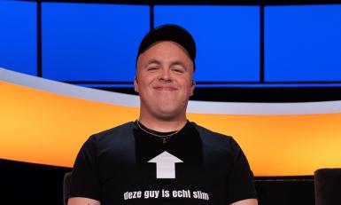 Lachende man met pet en de tekst 'deze guy is echt slim' op z'n t-shirt