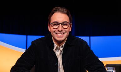 Jongen met bril en zwart vest in de studio