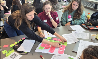 Studenten tijdens brainstorm met post-its aan de slag in zaal