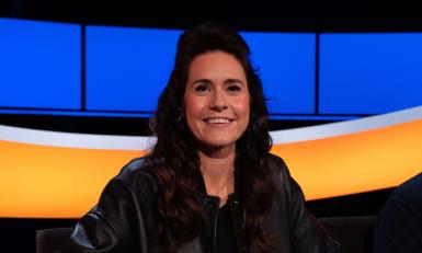 Lachende vrouw met zwart haar en zwarte jack