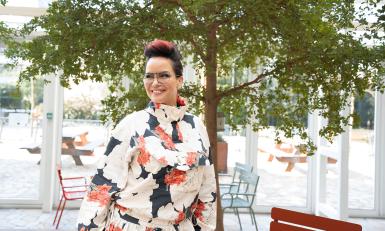 Mevrouw met bloemenprint shirt voor een boom