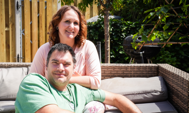 Een man en een vrouw op een bank in de tuin