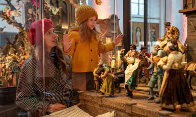 Meisje en vrouw kijken naar kerststal