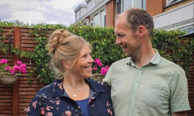 Een man en een vrouw kijken elkaar lachend aan