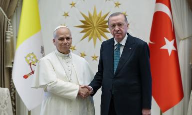 This handout photograph taken and released by the Turkish presidential press service on November 27, 2025, shows Turkey's President Recep Tayyip Erdogan (R) shaking hands with Pope Leo XIV during an official welcoming ceremony at the Presidential Complex in Ankara. Pope Leo XIV arrived in Turkey on the first overseas trip of his papacy, which will also take him to Lebanon. Handout / TURKISH PRESIDENTIAL PRESS SERVICE / AFP