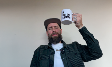 een man houdt een mok in de lucht