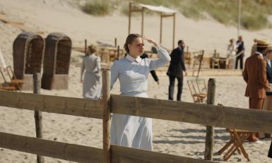 Een vrouw loopt over het strand