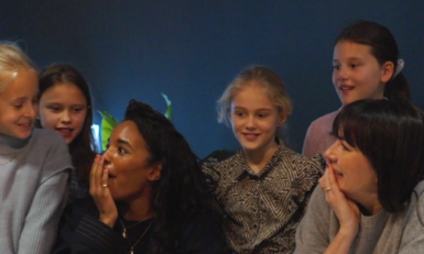 Twee vrouwen en meisjes aan een tafel