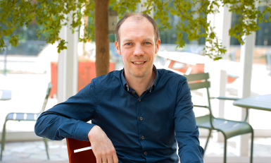 Meneer met blauw overhemd onder een boom