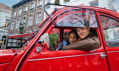 twee mensen in een rode auto