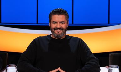 Lachende man met zwart haar en een zwarte baard 