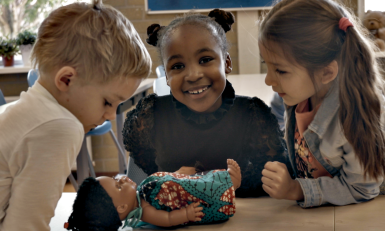 Nyah Nameh met klasgenoten en haar pop