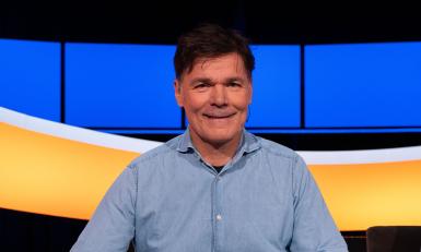 Man met bruin haar en blauw overhemd