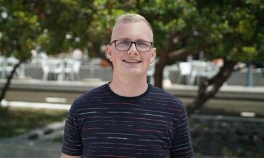 Man met bril lachend in camera met zwart shirt