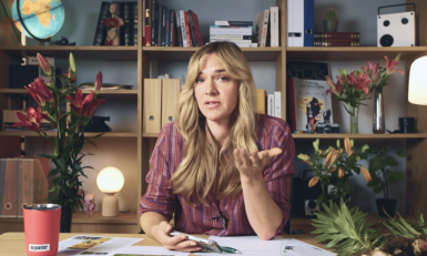 Presentator Marijn Frank aan tafel met lelies