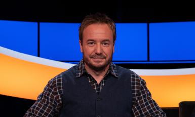 Man met geruite blouse en blauw gilet 