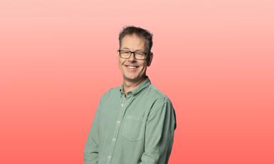 Man in groene blouse voor rode achtergrond