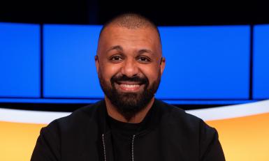 Lachende man met zwarte baard en zwart vest