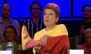 Vrouw houdt haar voet met roze sok omhoog