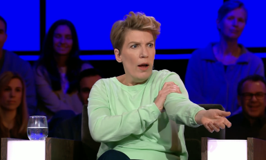 Vrouw met groene trui houdt haar arm vast