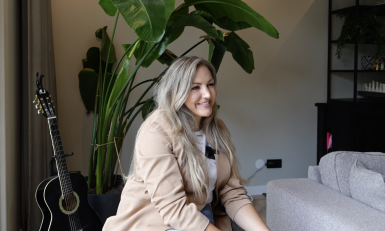 Lachende blonde vrouw in een woonkamer